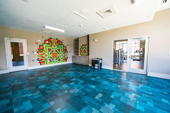 A room with a blue tiled floor and a large mandala painting on the wall at The Collective NoDa, Charlotte