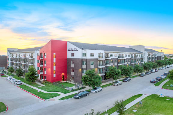 an exterior view of an apartment building with a parking lot
