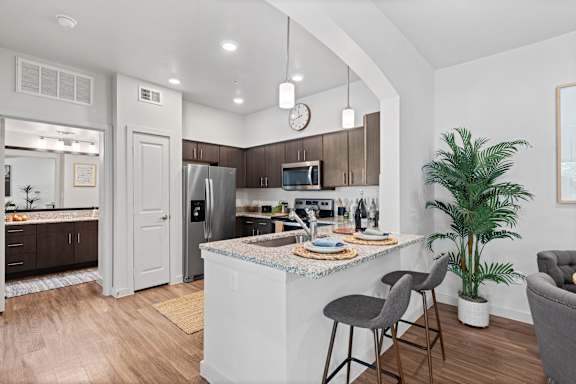 a kitchen with a island and a counter top with two chairs
