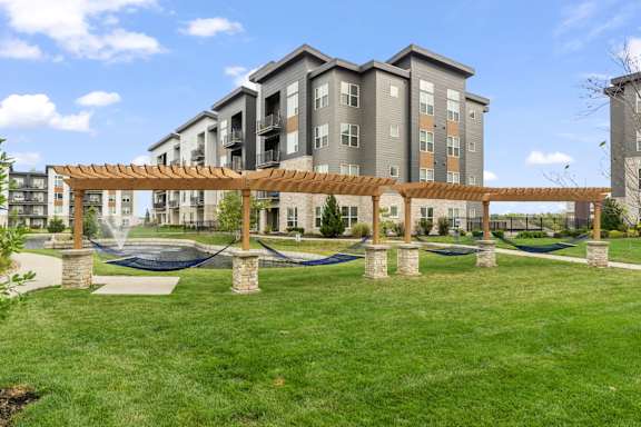 a park with hammocks in front of an apartment building