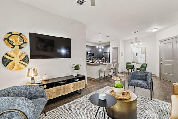 A living room with a blue chair and a gold side table.