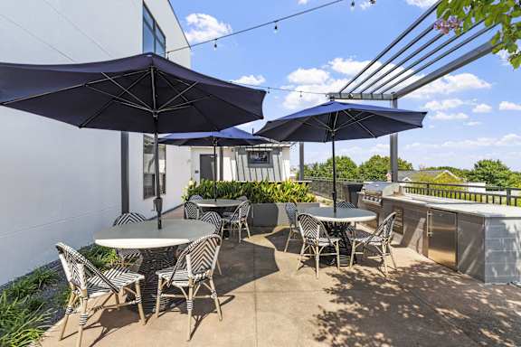 a patio with tables and chairs and umbrellas