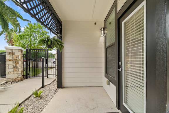 A black gate leads to a white garage.