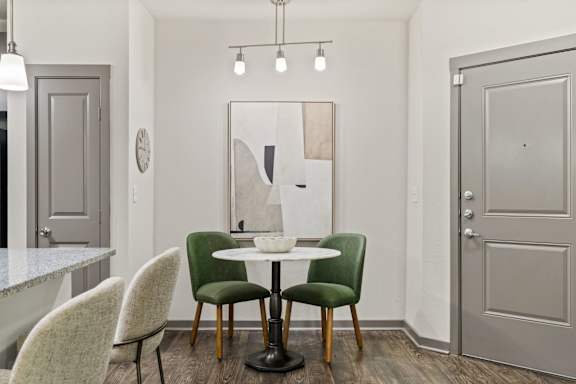 A dining room with a table and chairs.