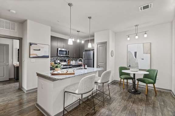 A modern kitchen with a bar area and a dining table.