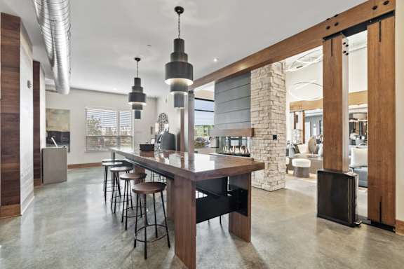 the kitchen has a large island with stools and a stone fireplace