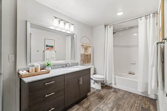 A bathroom with a wooden floor and white walls.
