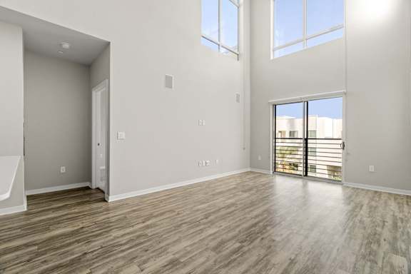 the living room of a new home with a large window and wooden floors