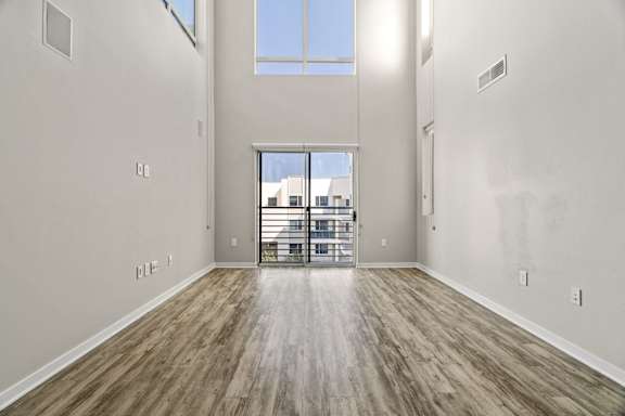 the living room of a new home with a balcony and wood flooring