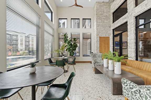 a living room with a large window and a table with chairs