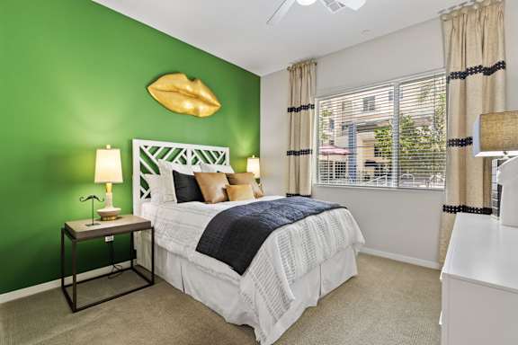 a bedroom with a green wall and a white bed