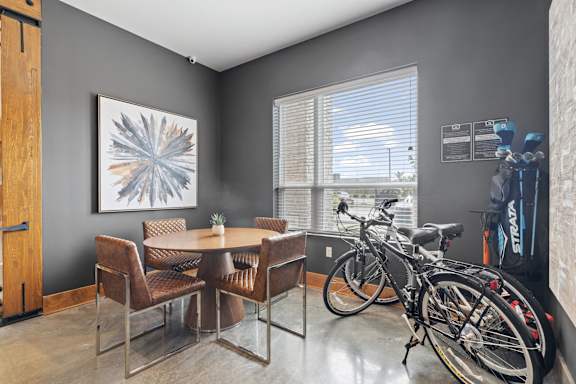 a dining room with a table and two bikes in front of a window