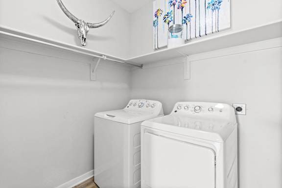 a white laundry room with two washes and a dryer