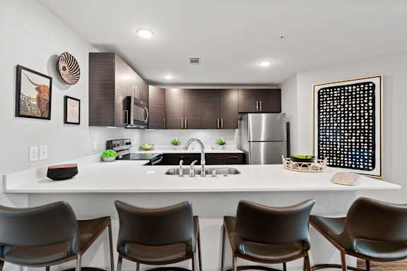 a kitchen with a large island with four chairs in front of it