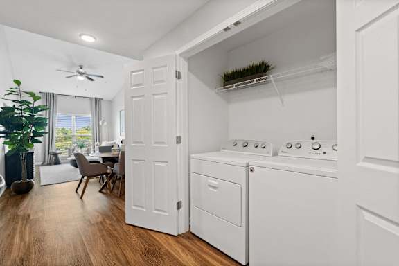 an open kitchen with a washer and dryer and a living room with a