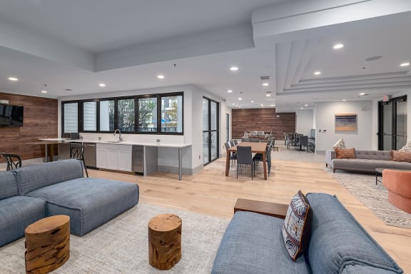 a living room with couches and chairs and a kitchen