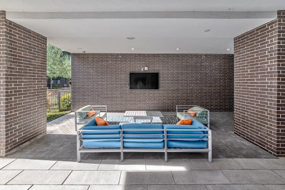 a lounge area with a couch and a table in front of a brick wall