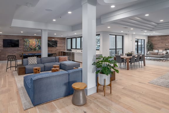a living room and dining room with blue couches and a table