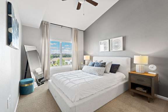 a bedroom with a bed and a window and a ceiling fan