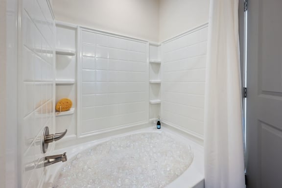 a white bathroom with a shower and a tub and a shower curtain