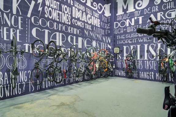 a wall with many bikes parked against it