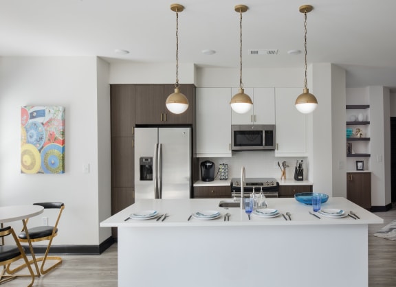a kitchen and dining area with a white island and stainless steel appliances
