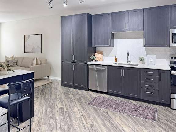 A kitchen with dark wood cabinets and a white backsplash.