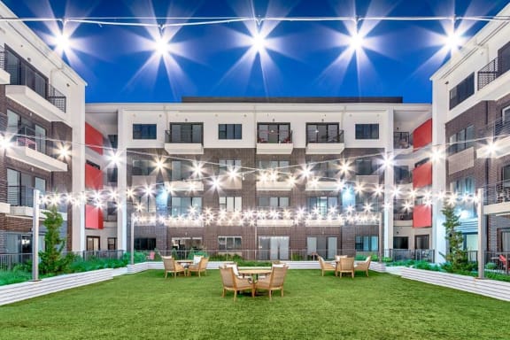 an open courtyard with tables and chairs in an apartment building
