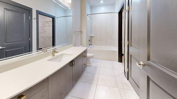 A bathroom with a sink, mirror, and toilet.