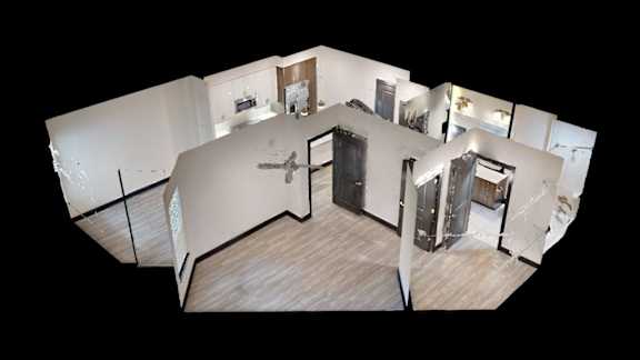A white room with a wooden floor and a large mirror on the wall.