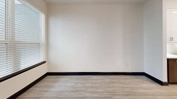 A room with a window and a wooden cabinet.