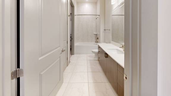 A white bathroom with a toilet, sink, and mirror.