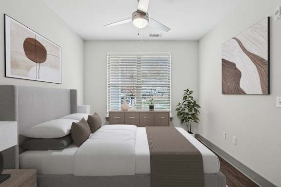 A bedroom with a bed, nightstand, and a ceiling fan.