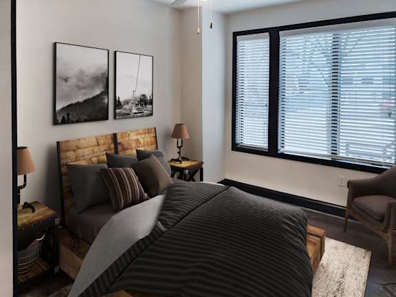 A bedroom with a large bed and two lamps.