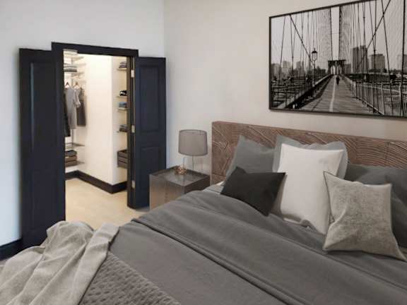 A bedroom with a large bed and a bridge picture on the wall.