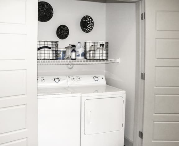 a white washer and dryer in a white laundry room