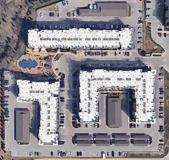an aerial view of a parking lot and buildings