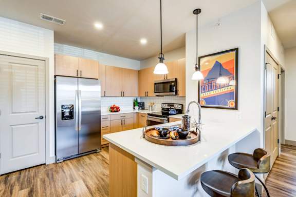 A kitchen with a refrigerator, microwave, and a sink.
