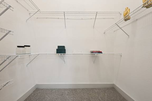 A white wall with metal shelves and a green box on the shelf.