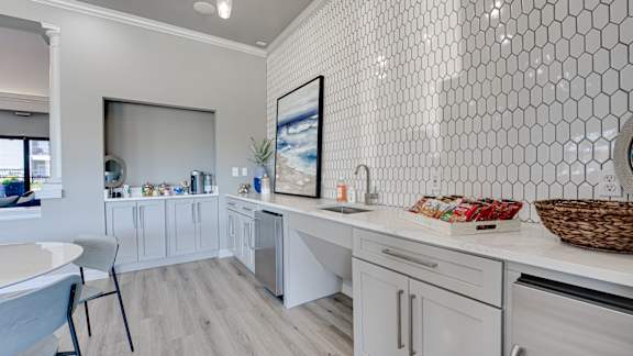 A kitchen with white cabinets and a white tiled wall. at Highland Luxury Living, Lewisville, TX, 75067
