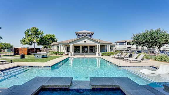 A large swimming pool in front of a house with a deck and sun loungers at Highland Luxury Living, Lewisville, TX, 75067