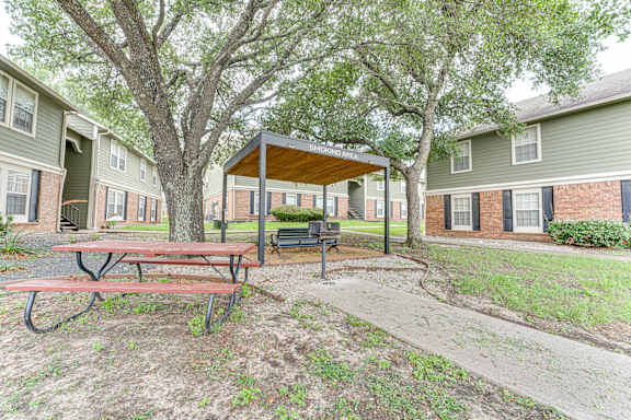 Covered smoking area with picnic table and benches at Arbors Of Corsicana Apartments, Texas, 75110