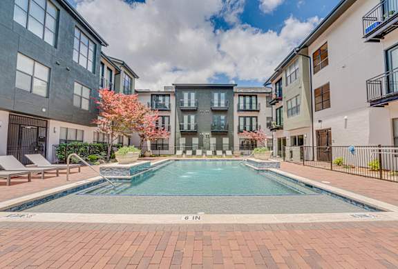 Courtyard pool with lounge chairs and landscaping at The Barton Apartments, Dallas