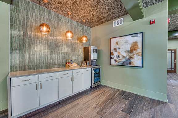 A kitchen with a green wall and wooden floors.