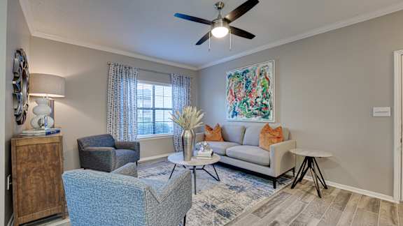 Living room with modern furniture and ceiling fan at Carmel Creekside Apartments, Fort Worth, 76137