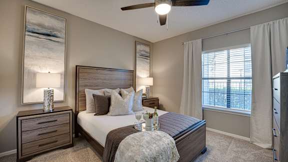 Bedroom with wooden furniture and ceiling fan at Carmel Creekside Apartments, Fort Worth