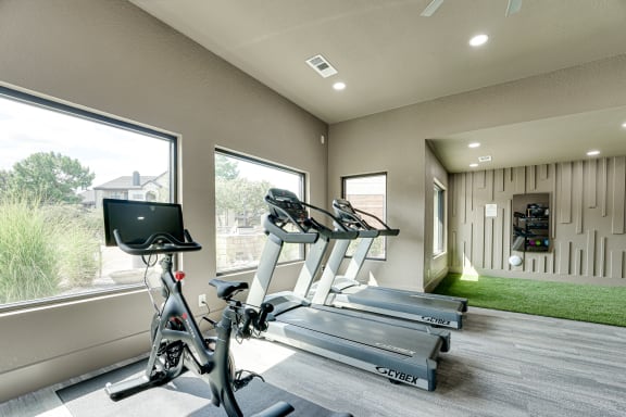 Fitness room with cardio equipment and turf area at Carmel Creekside Apartments, Texas