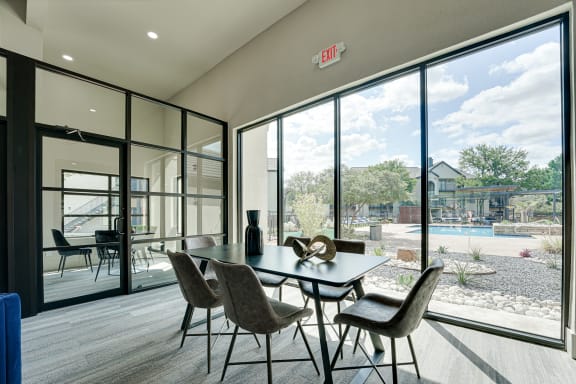 Community room with dining table and pool view at Carmel Creekside Apartments, Texas, 76137