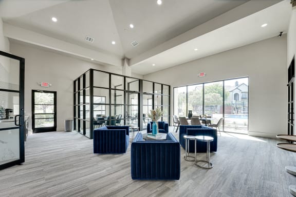 Clubhouse lounge with blue velvet seating and glass partitions at Carmel Creekside Apartments, Fort Worth, TX 76137