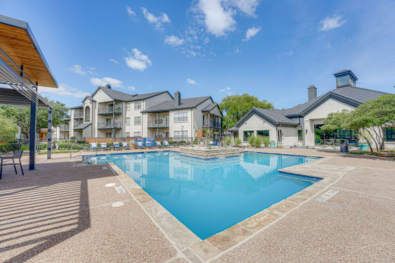 Swimming pool with sundeck and clubhouse building at Carmel Creekside Apartments, Fort Worth, Texas